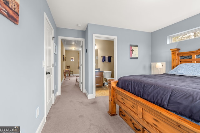 bedroom featuring light carpet and ensuite bath