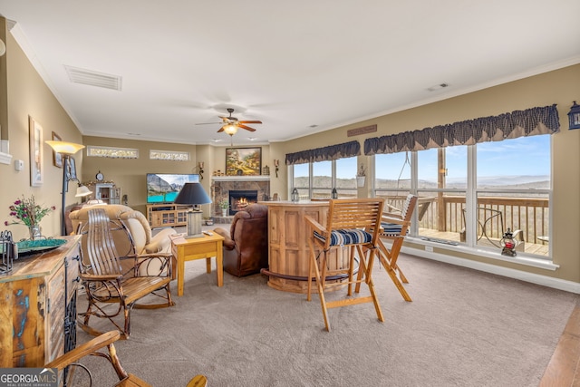 carpeted living room featuring ornamental molding and ceiling fan