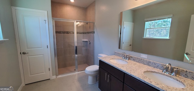 bathroom featuring vanity, a shower with shower door, and toilet