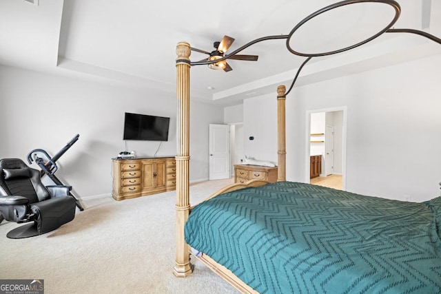 bedroom with a raised ceiling, light colored carpet, and ceiling fan