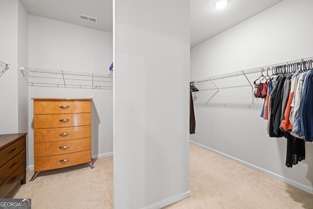 walk in closet featuring light carpet