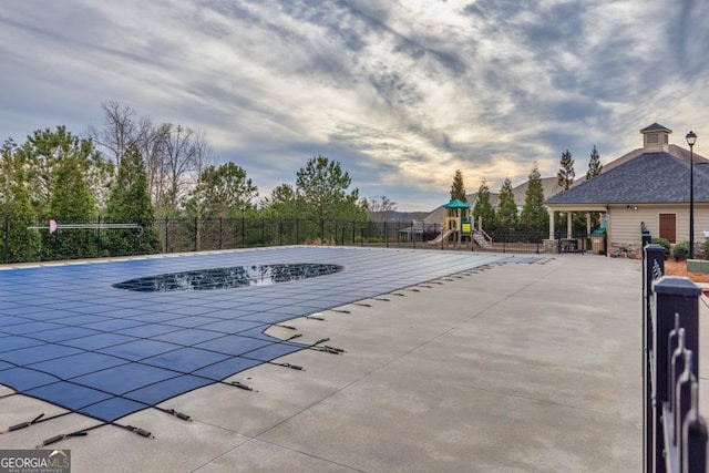 view of pool featuring a playground and a patio