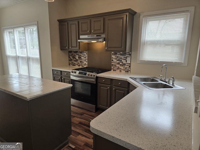 kitchen with sink, dark brown cabinets, stainless steel range with gas stovetop, dark hardwood / wood-style flooring, and decorative backsplash