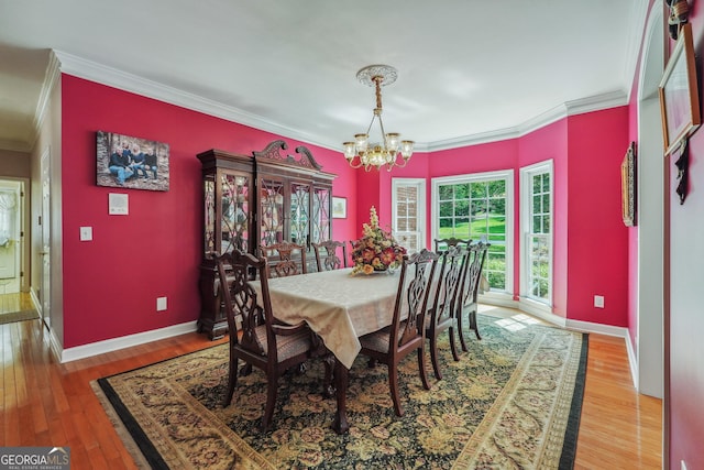 dining area with an inviting chandelier, crown molding, and hardwood / wood-style flooring