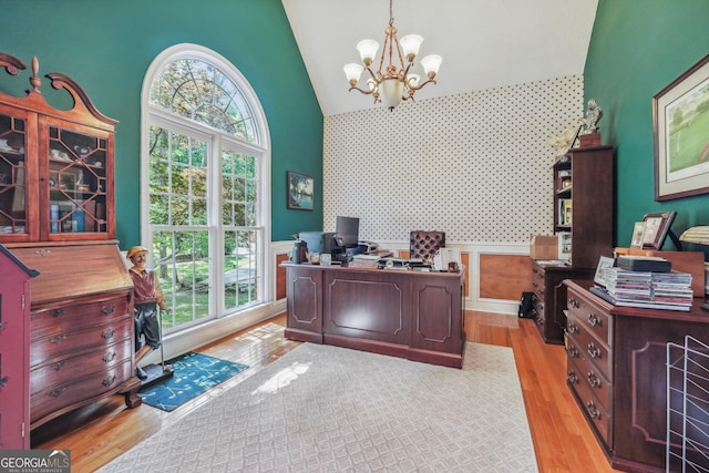 home office featuring a notable chandelier, high vaulted ceiling, and light hardwood / wood-style flooring