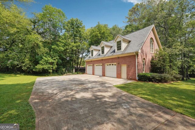 view of side of home featuring a yard and a garage