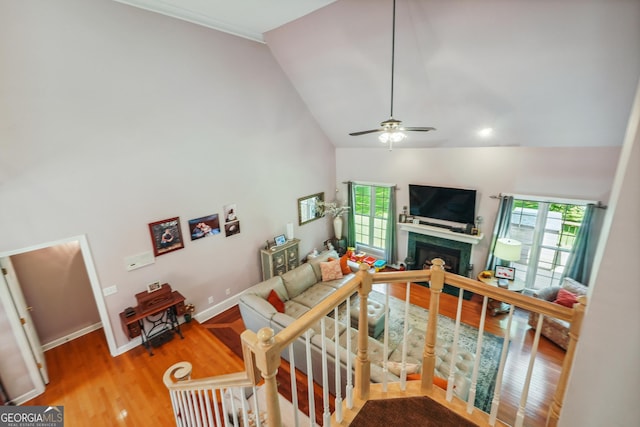 living room with plenty of natural light, high vaulted ceiling, and wood-type flooring