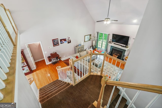 living room featuring hardwood / wood-style flooring, ceiling fan, and high vaulted ceiling