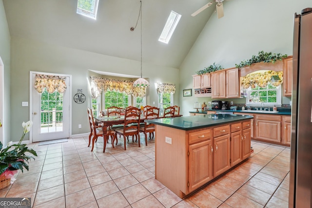 kitchen with a skylight, sink, a kitchen island, and light tile patterned floors