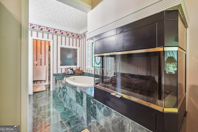 bathroom with crown molding, tiled bath, and a textured ceiling