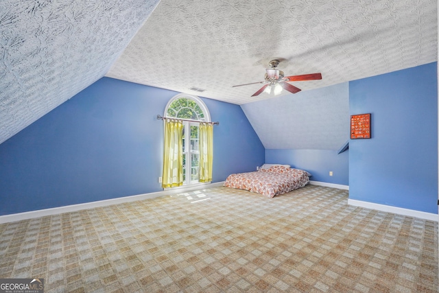 unfurnished bedroom featuring light carpet, ceiling fan, lofted ceiling, and a textured ceiling