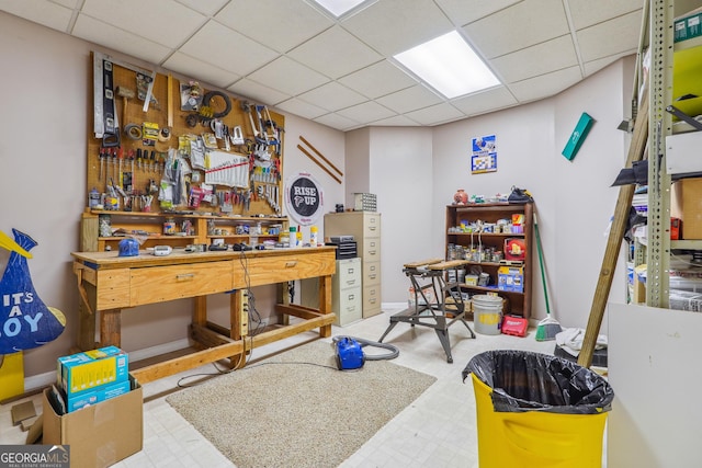 interior space with a drop ceiling and a workshop area