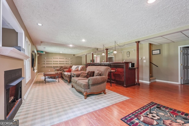 living room with wood-type flooring and a textured ceiling