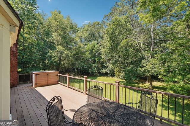 wooden deck featuring a lawn