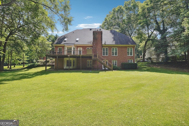 rear view of house featuring a wooden deck and a lawn