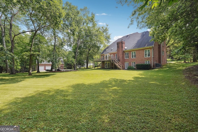 view of yard with a deck and central air condition unit