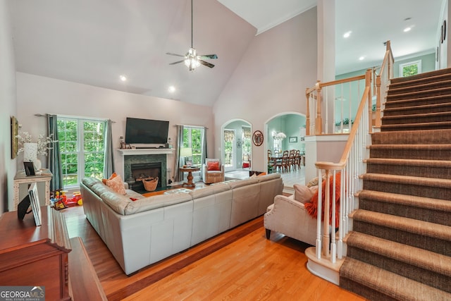 living room featuring high vaulted ceiling, light hardwood / wood-style floors, and ceiling fan