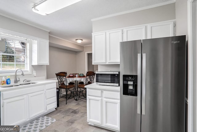 kitchen with a sink, white cabinetry, and stainless steel appliances