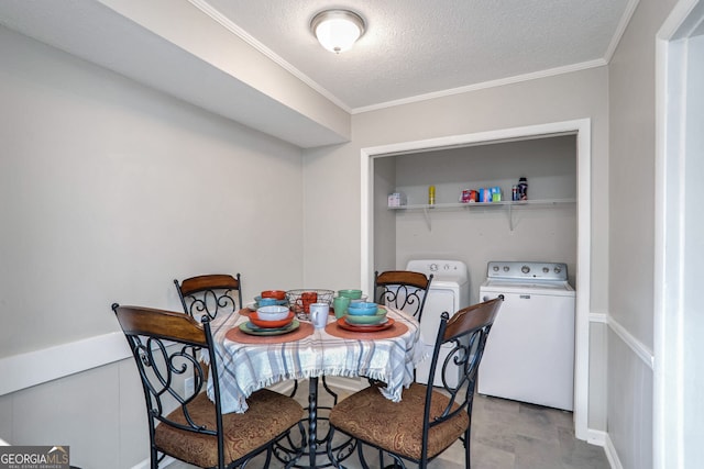 dining room featuring a textured ceiling, crown molding, and washer and clothes dryer