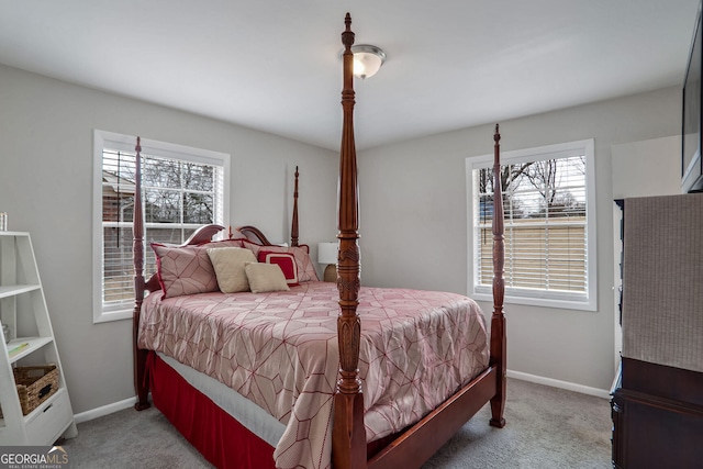 bedroom with multiple windows, light carpet, and baseboards