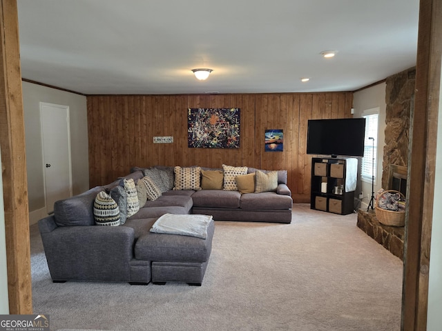 living room with a fireplace, carpet flooring, and wood walls