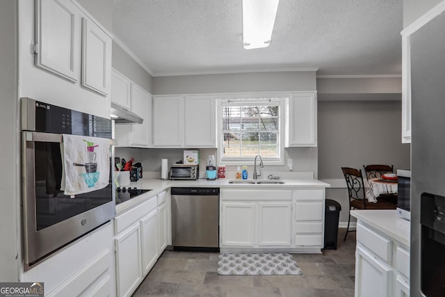 kitchen with a sink, stainless steel appliances, light countertops, under cabinet range hood, and white cabinetry