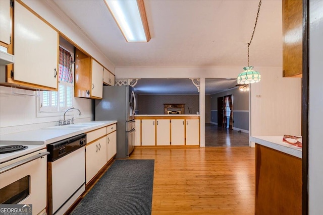 kitchen featuring white cabinetry, hanging light fixtures, white appliances, and sink