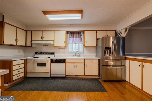 kitchen featuring sink, a textured ceiling, white appliances, and light hardwood / wood-style flooring