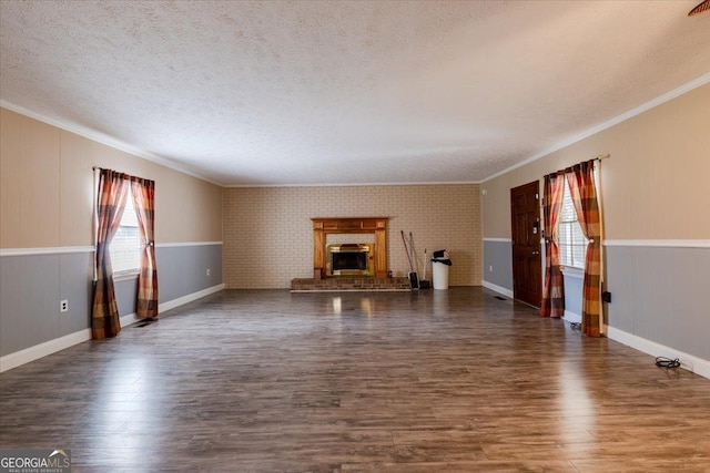 unfurnished living room featuring a fireplace, ornamental molding, dark hardwood / wood-style floors, and a textured ceiling