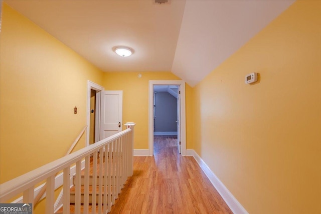 corridor with lofted ceiling and light wood-type flooring