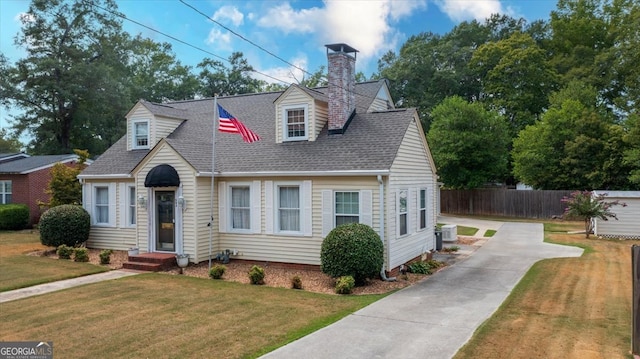 new england style home with central AC unit and a front yard