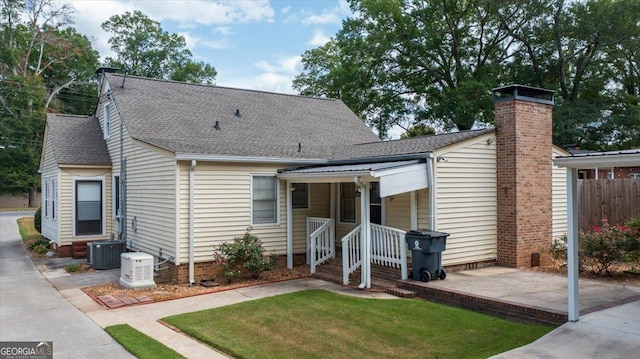 view of front of property featuring central AC unit, a patio area, and a front lawn