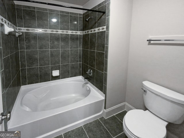 bathroom featuring toilet, tiled shower / bath combo, and tile patterned flooring