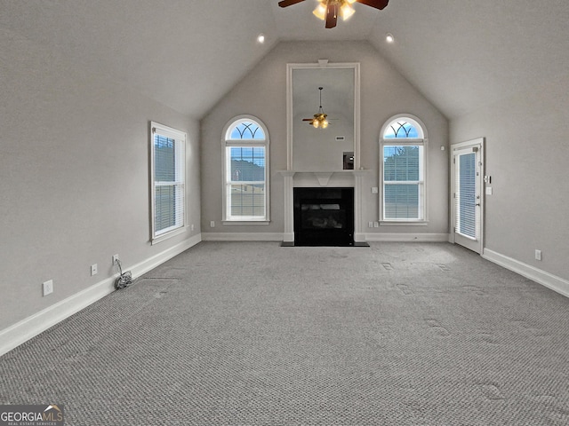 unfurnished living room with carpet, high vaulted ceiling, and ceiling fan