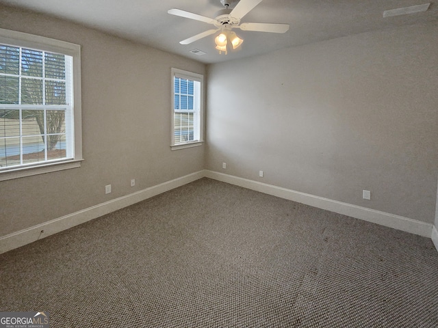 carpeted spare room featuring ceiling fan and a healthy amount of sunlight