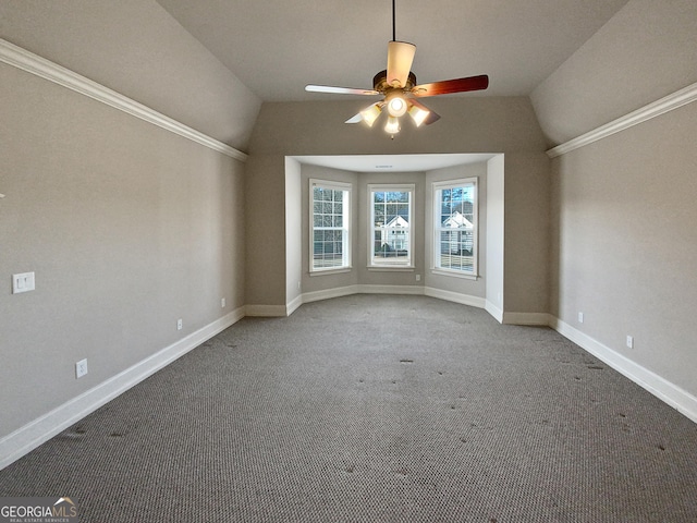 carpeted spare room with vaulted ceiling, crown molding, and ceiling fan