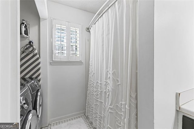 bathroom with curtained shower, washing machine and dryer, and a textured ceiling