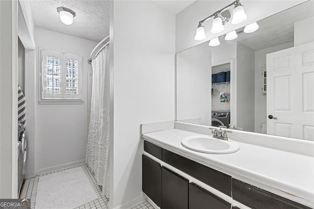 bathroom with vanity, washer / clothes dryer, tile patterned flooring, and a textured ceiling