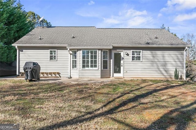 rear view of property with a yard and a patio area