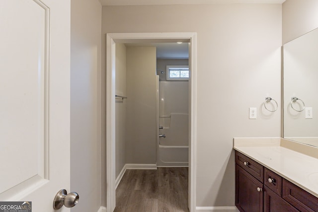 bathroom featuring vanity, wood-type flooring, and shower / bathing tub combination