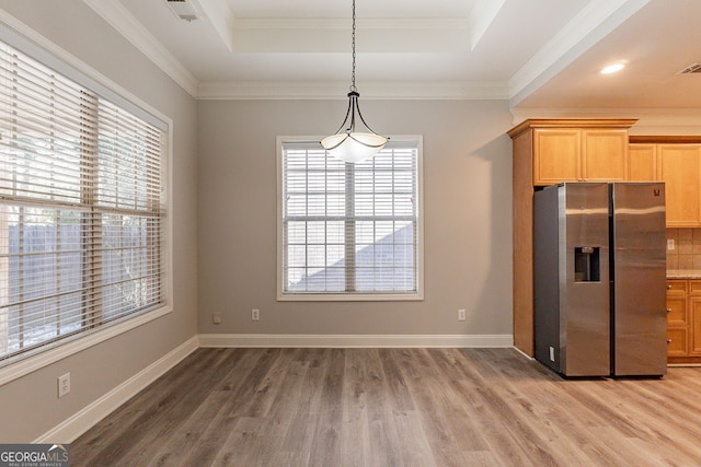 kitchen with stainless steel refrigerator with ice dispenser, a tray ceiling, and crown molding