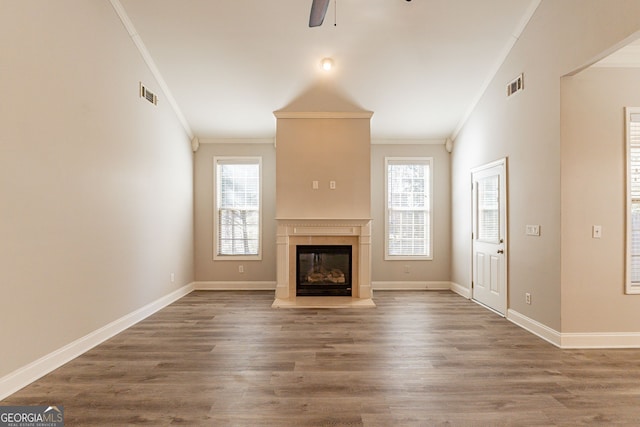 unfurnished living room featuring dark wood-type flooring, ceiling fan, ornamental molding, and lofted ceiling