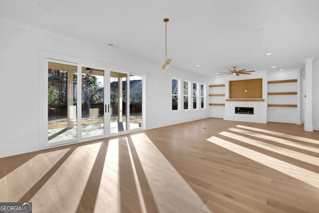 unfurnished living room featuring ceiling fan and light hardwood / wood-style flooring