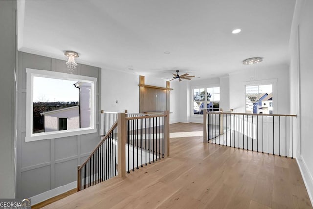 corridor with a notable chandelier and light hardwood / wood-style flooring