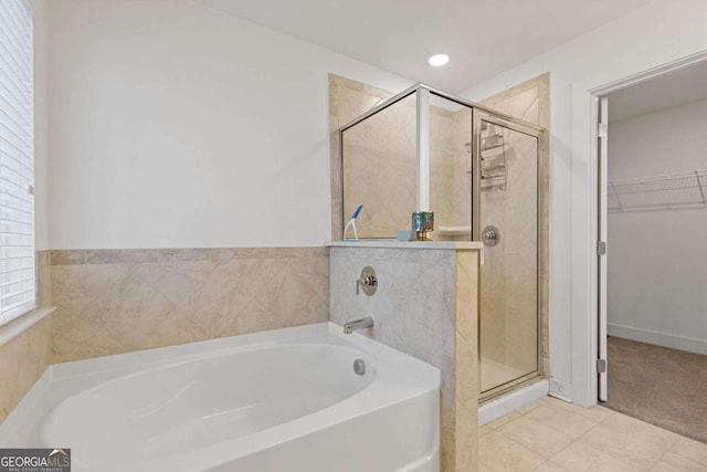 bathroom featuring a shower with door, tile patterned flooring, and a wealth of natural light