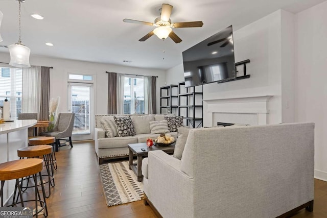 living room featuring dark hardwood / wood-style flooring and ceiling fan