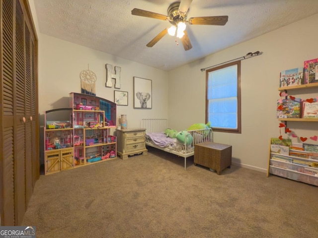 bedroom featuring a textured ceiling, carpet floors, a closet, and ceiling fan