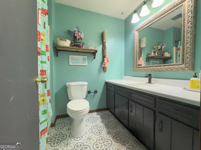 bathroom featuring vanity, toilet, and tile patterned flooring