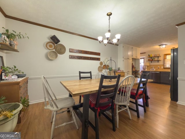 dining area with crown molding, a chandelier, hardwood / wood-style floors, and a textured ceiling