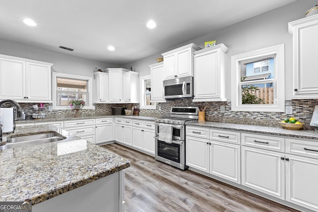 45 Misty Creek Cv, Newnan, GA 30265 - kitchen featuring stainless steel appliances, a sink, recessed lighting, light wood-type flooring, and tasteful backsplash